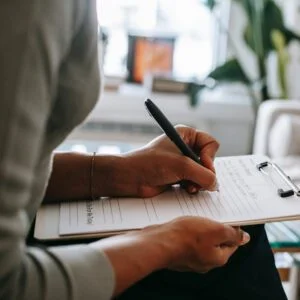 Psychologist Writing on Clipboard During Therapy Session